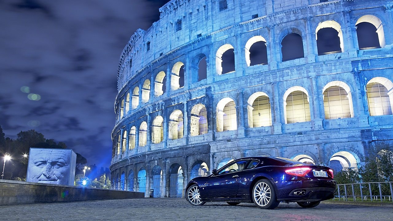 Auto negro por la noche delante del Coliseo