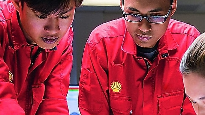 Three employees reviewing plans