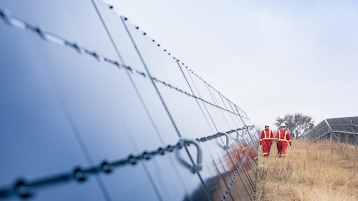 Dos empleados de Shell caminan entre enormes paneles solares