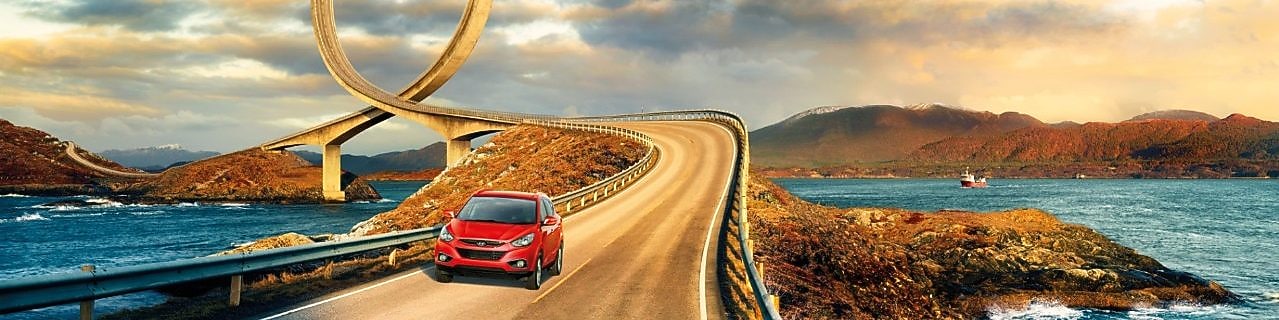 Auto rojo circulando por la ruta junto al río