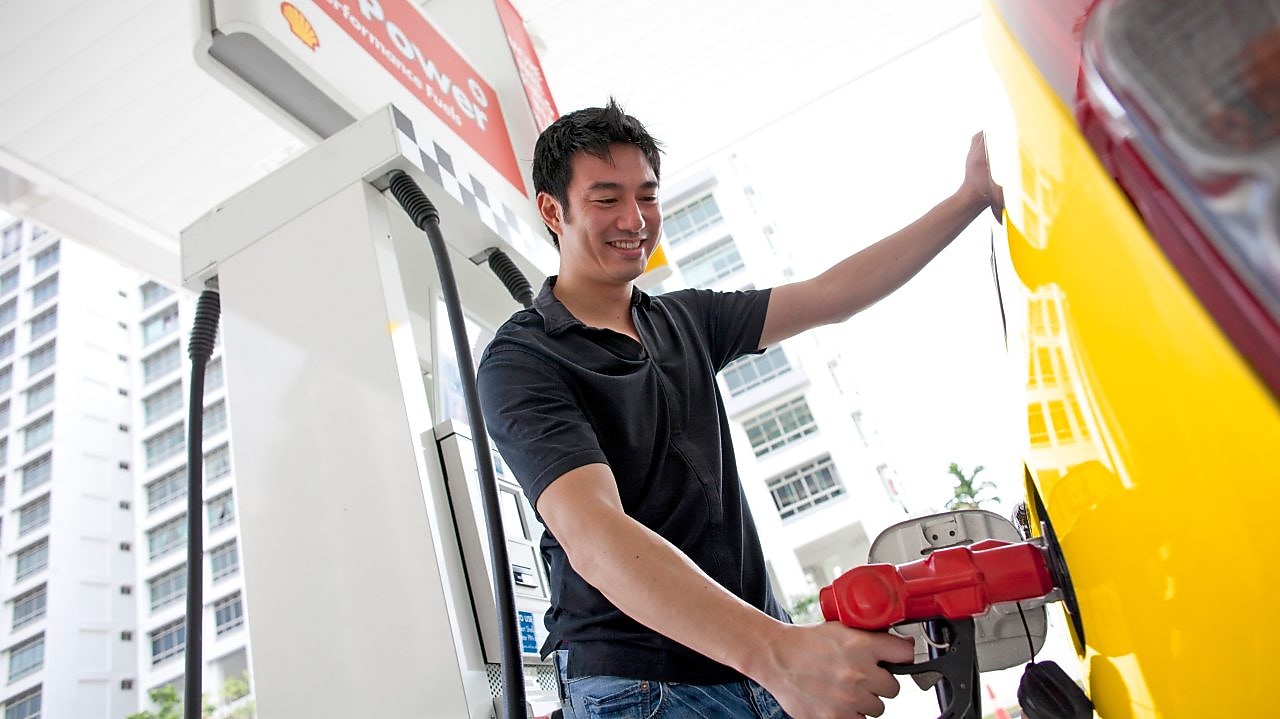 Usuario cargando combustible en una estación de servicio.