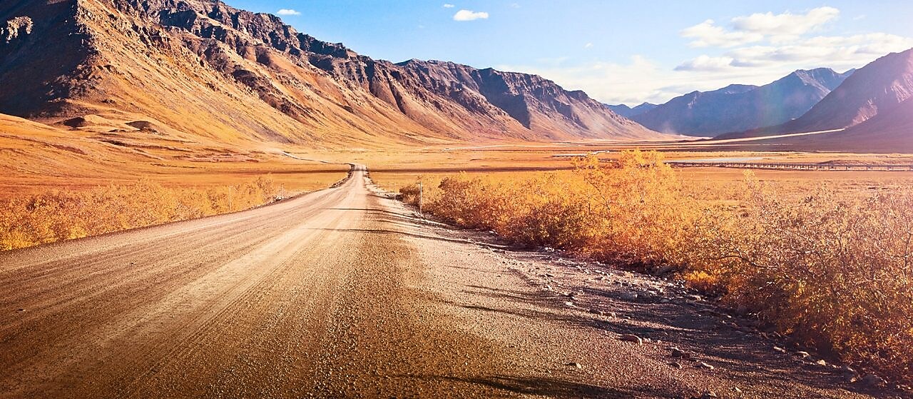 Ruta desierta sin asfaltar rodeada de montañas