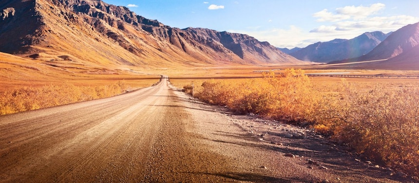 Ruta desierta sin asfaltar rodeada de montañas