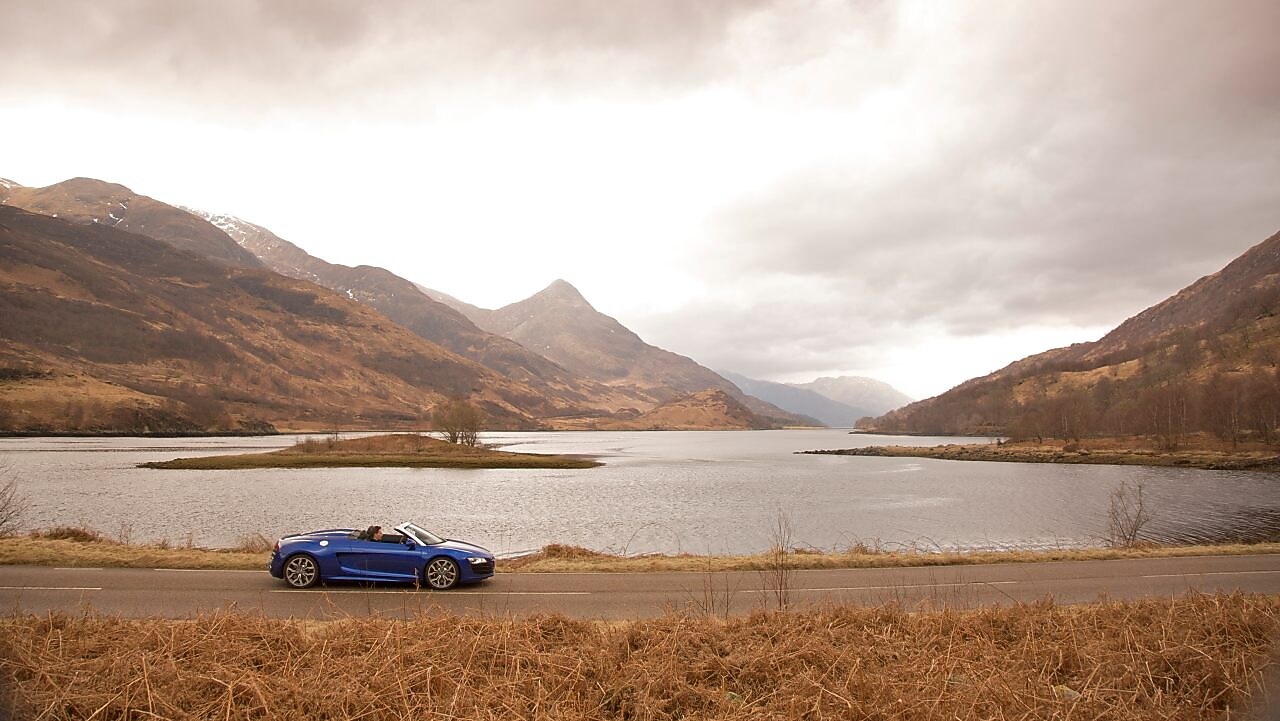 Auto en la ruta junto a un lago de montaña