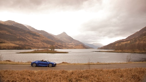 Auto en la ruta junto a un lago de montaña