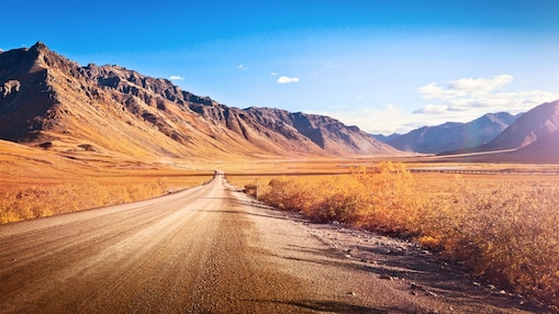 Ruta desierta sin asfaltar rodeada de montañas