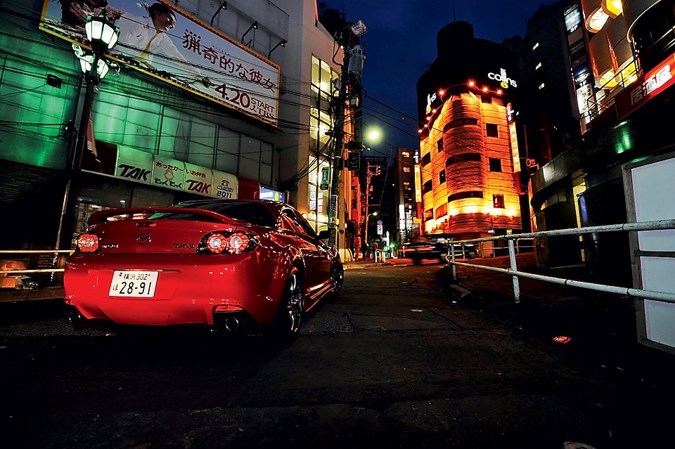 Mazda conduciendo de noche por Tokio
