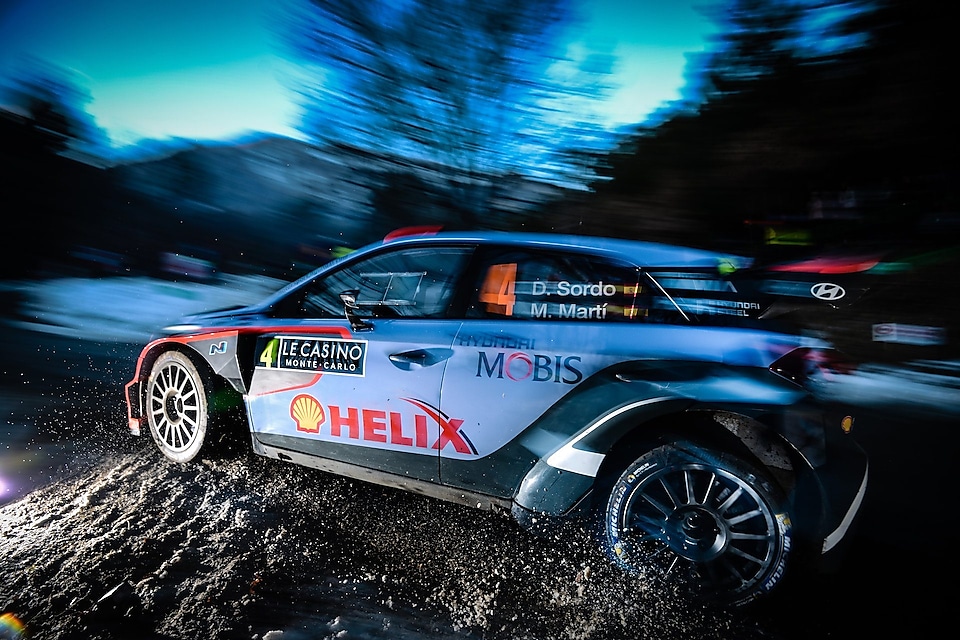 Coche de rally corriendo a gran velocidad al amanecer en el Campeonato del Mundo de Rally