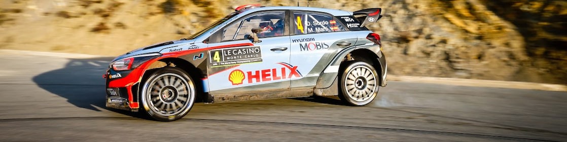 Coche de rally derrapando en una curva en el Campeonato del Mundo de Rally