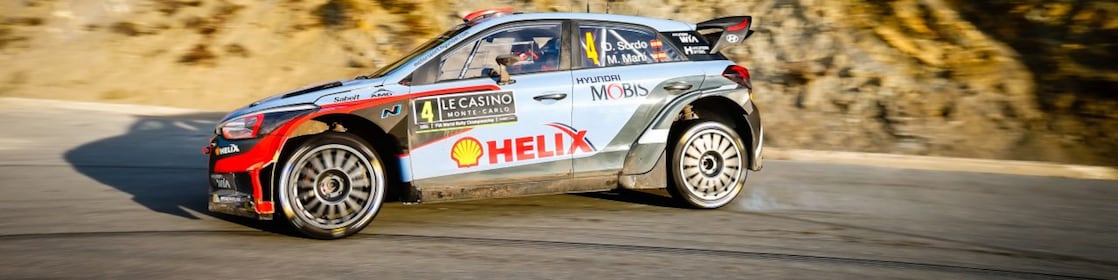 Coche de rally derrapando en una curva en el Campeonato del Mundo de Rally