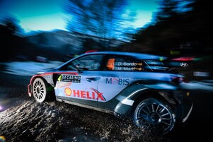 Coche de rally corriendo a gran velocidad al amanecer en el Campeonato del Mundo de Rally